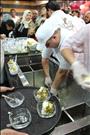 Employees scoop ice cream topped with pistachios at Bakdash's opening in Amman/ Nabih Bulos for NPR